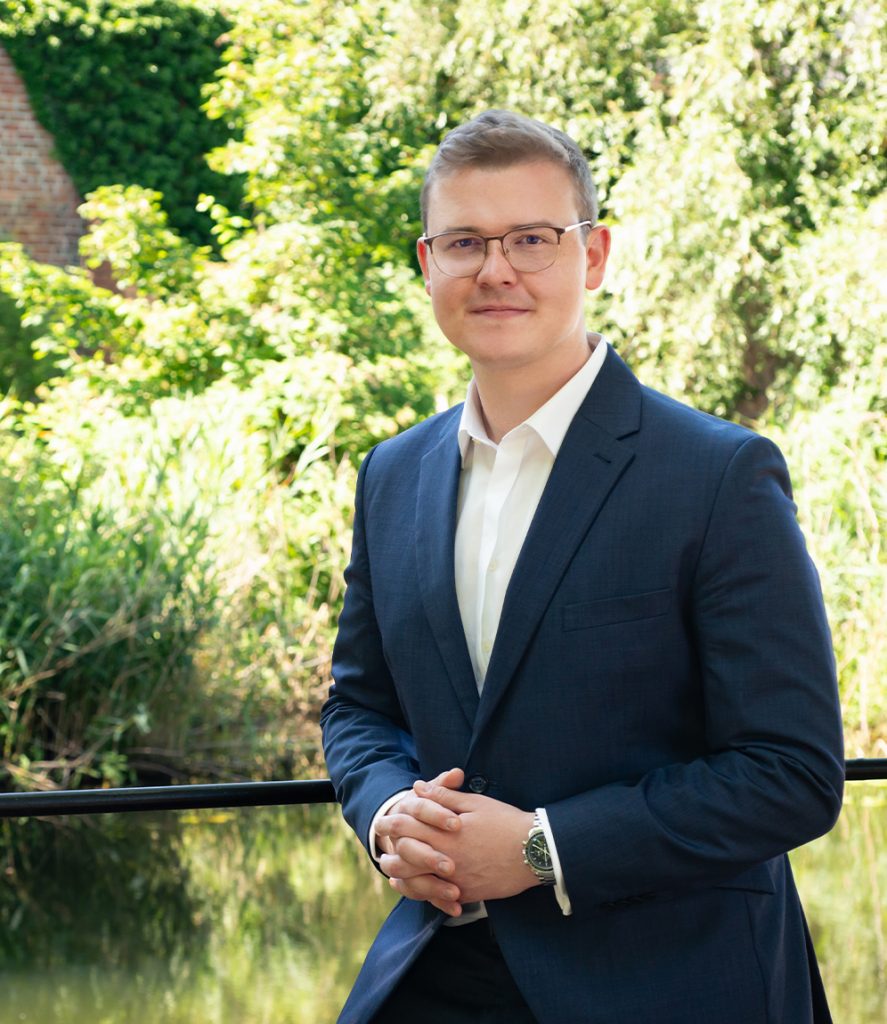 Portrait von Steuerberater Tim Eiselt vor Grünfläche